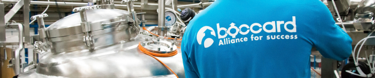 Techniciens en industrie avec logo Boccard dans un environnement industriel.